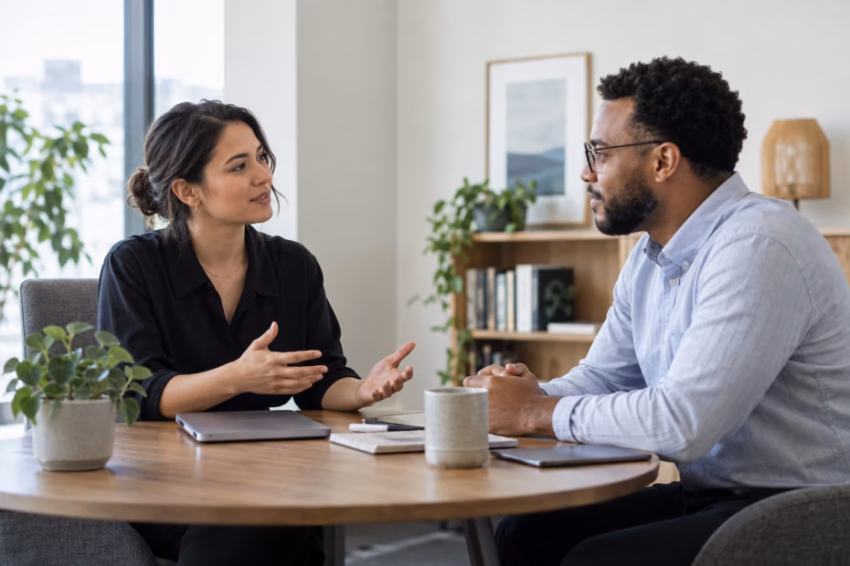 Two coworkers discussing a concern calmly across a meeting table