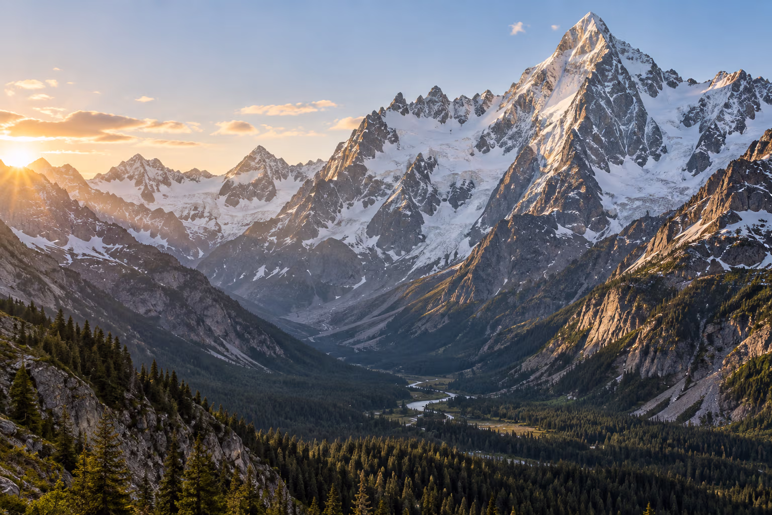 Snow-capped mountain peaks rise above a forested valley at sunrise.